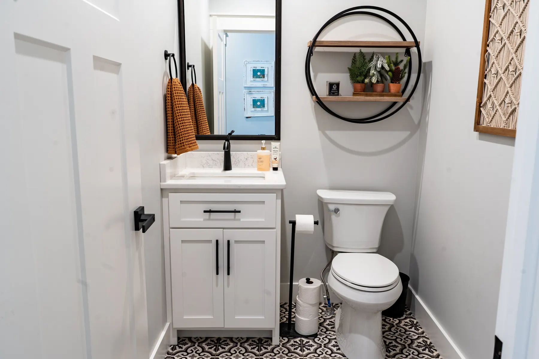 Compact white powder-room vanity with patterned floor tile