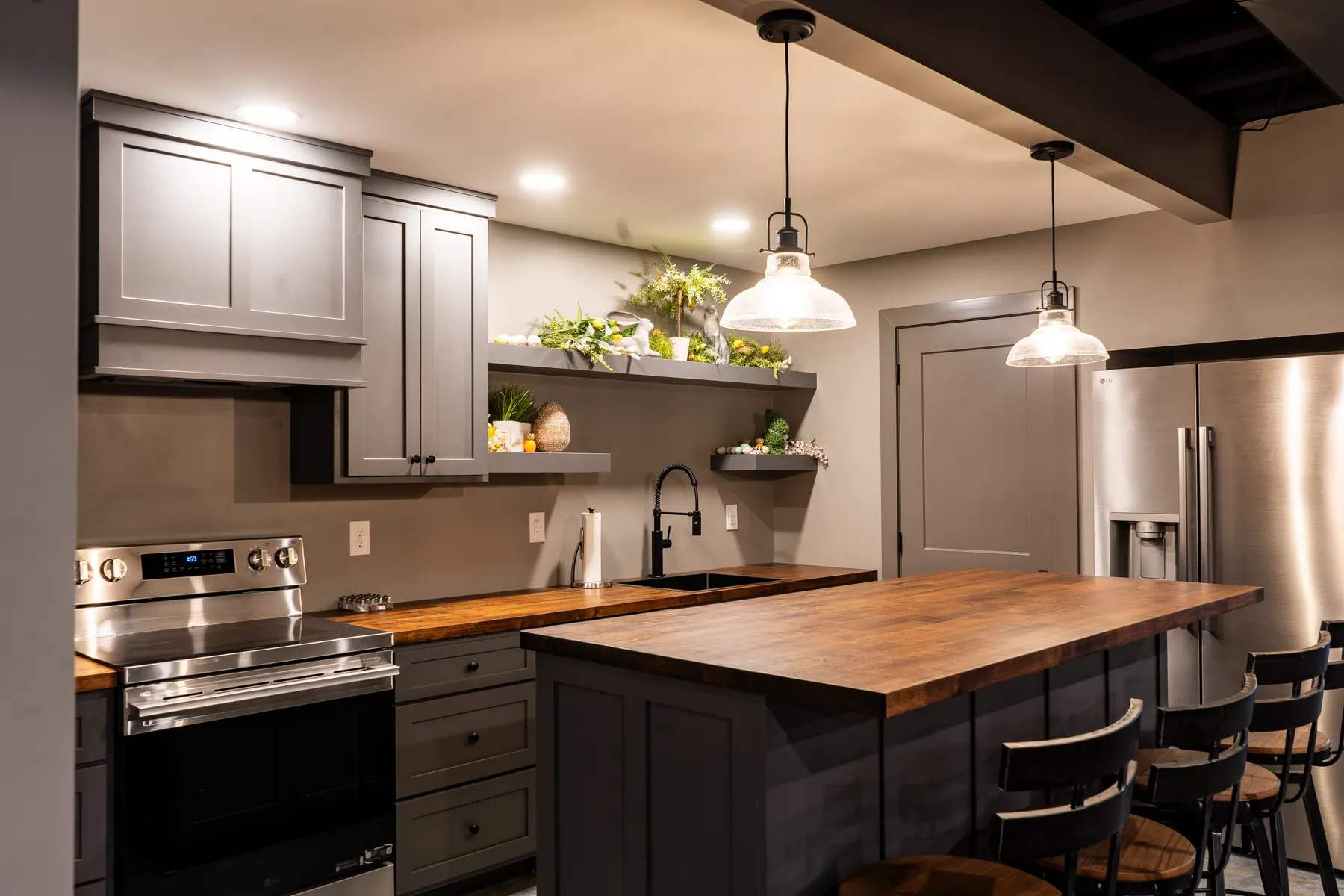 Charcoal gray kitchen with a butcher-block island and pendant lighting