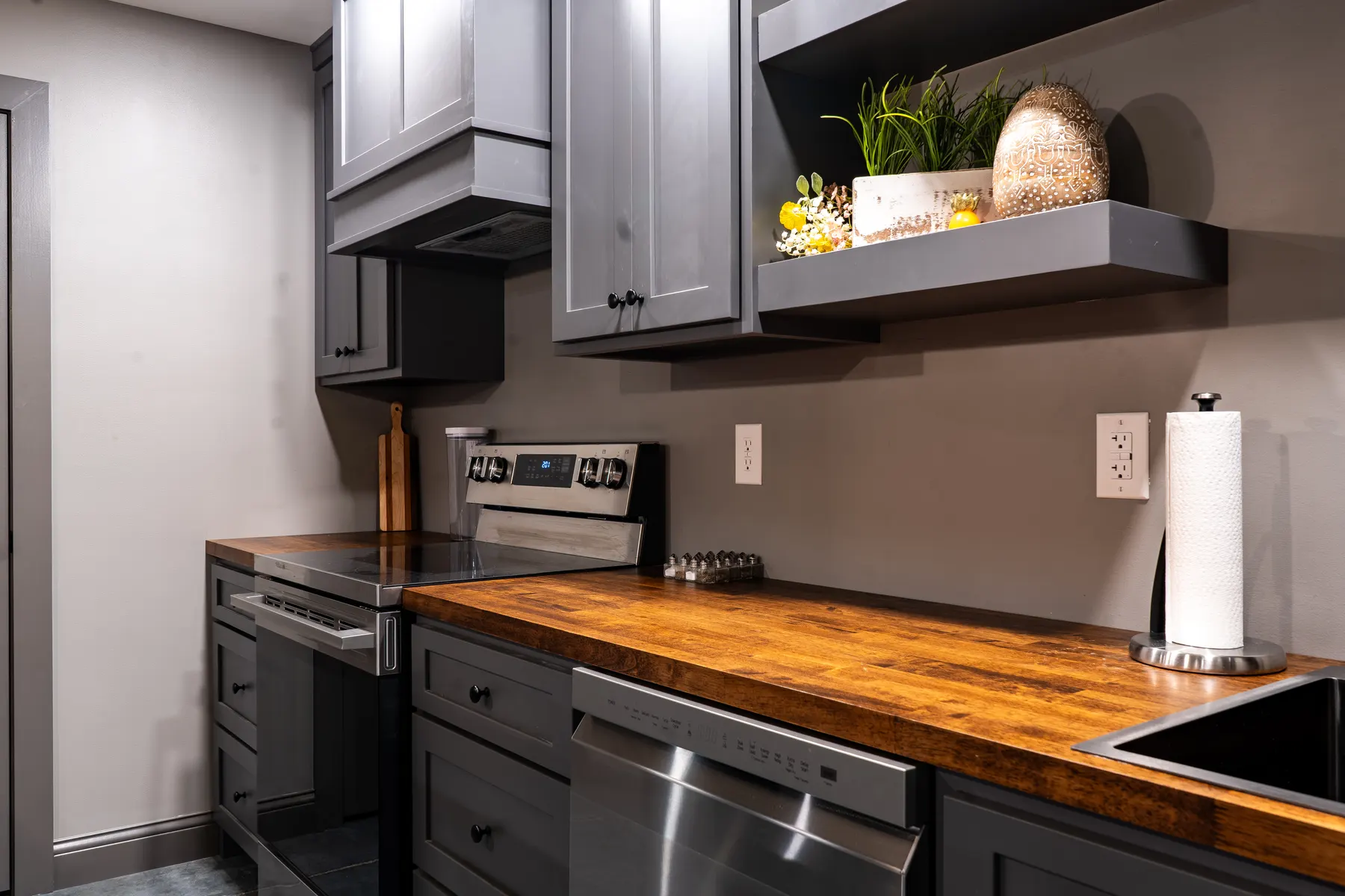 Charcoal shaker cabinets with butcher-block counters around a stainless range
