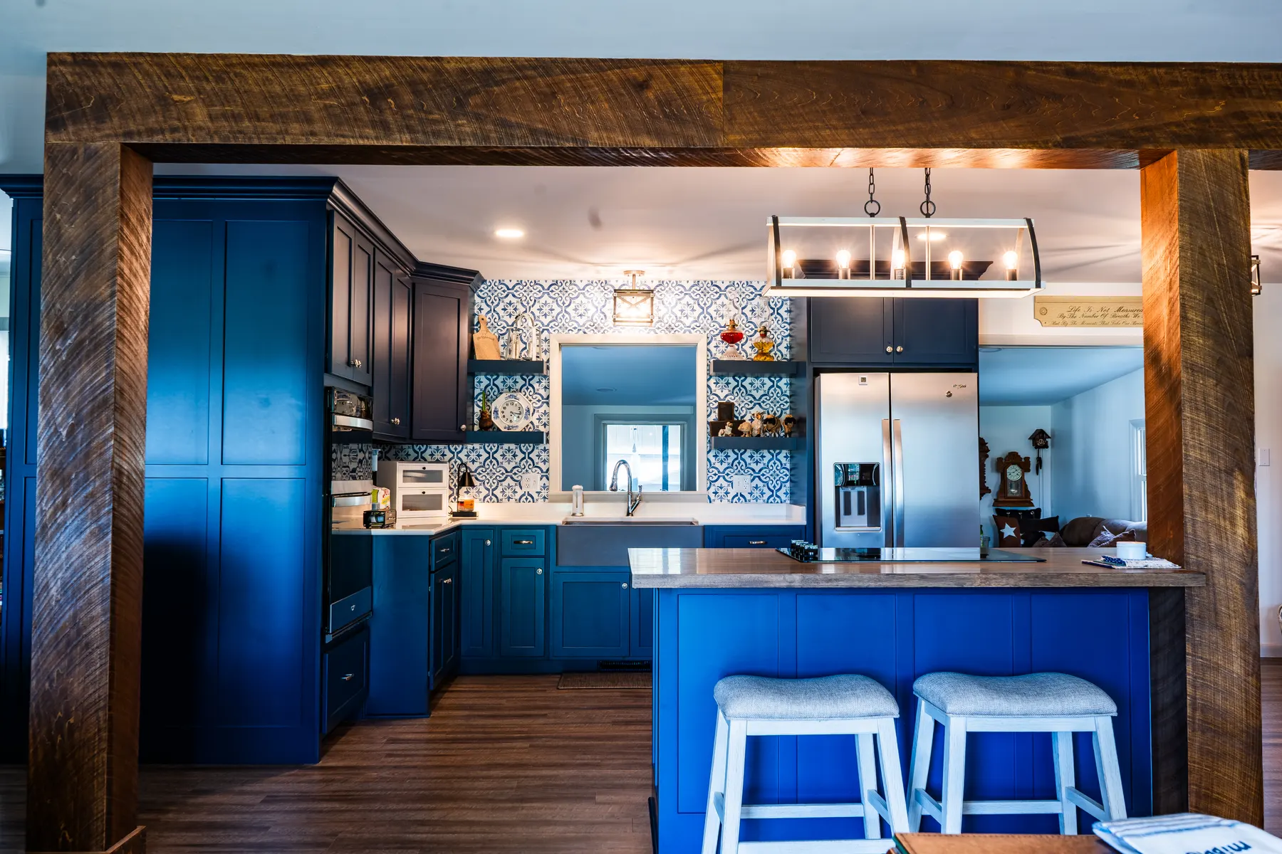 Navy blue kitchen with patterned tile, a wood-top island, and a farmhouse sink